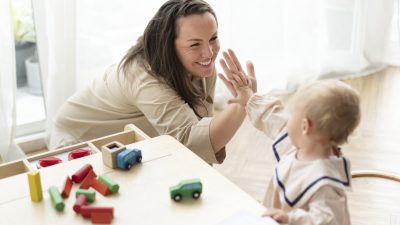 Mother and baby daughter giving high fives
